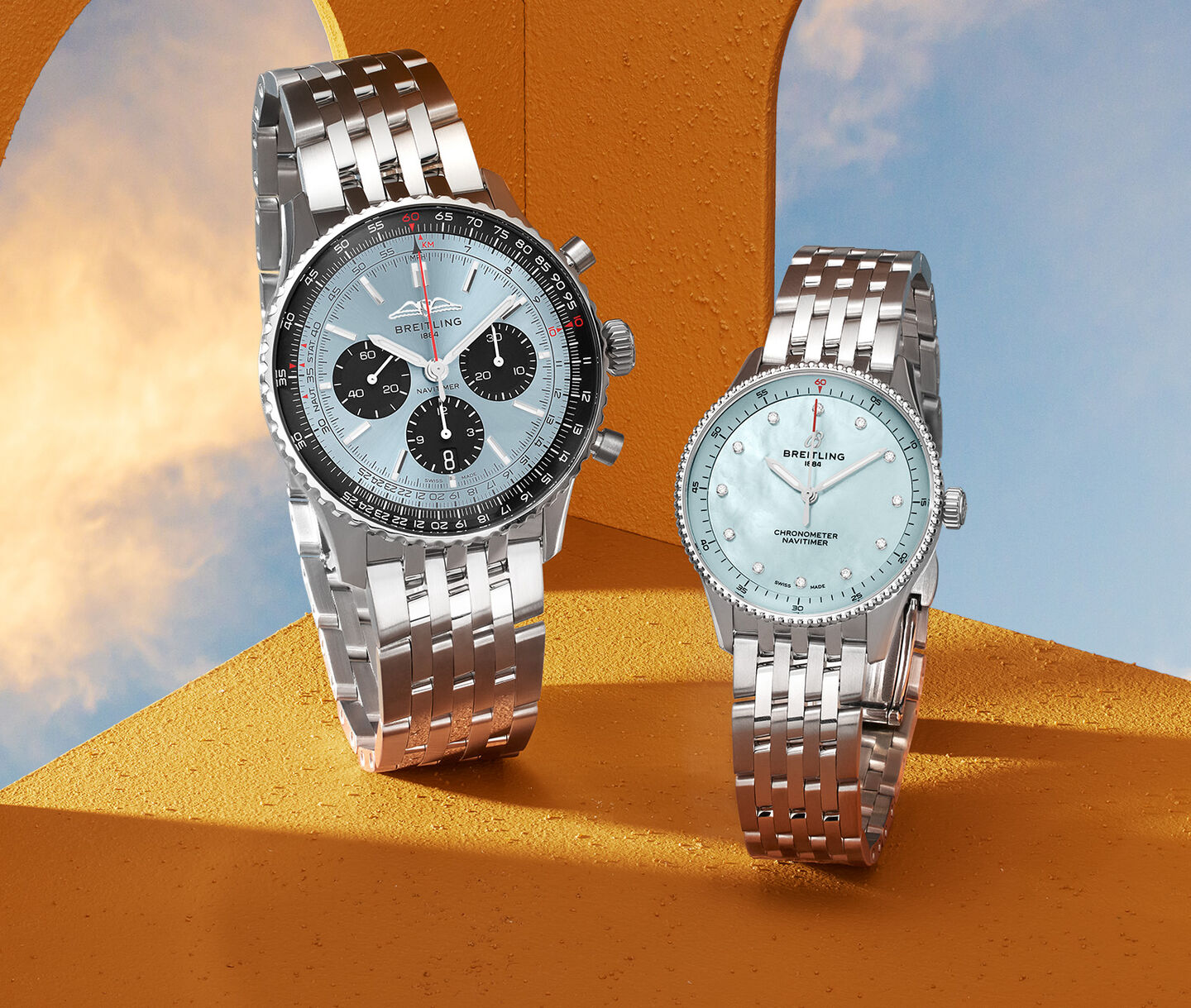 Two Breitling watches with blue faces on a background with the sky. 