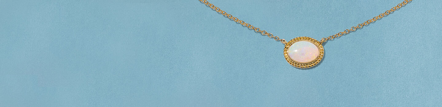 Collier Birks Essentiels opale et or jaune sur un fond bleu.