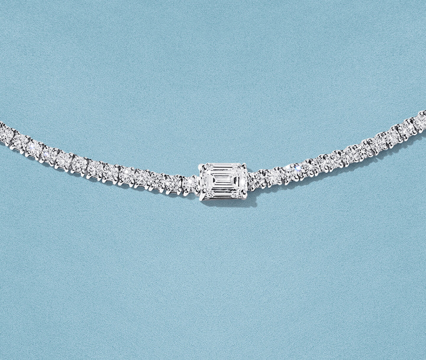 Birks Essentials diamond necklace on a blue background.