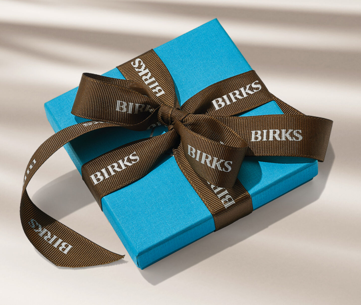 Maison Birks blue box on a beige background.