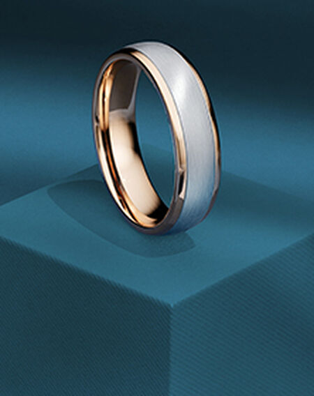 Alliance de mariage Birks pour lui sur un fond bleu.