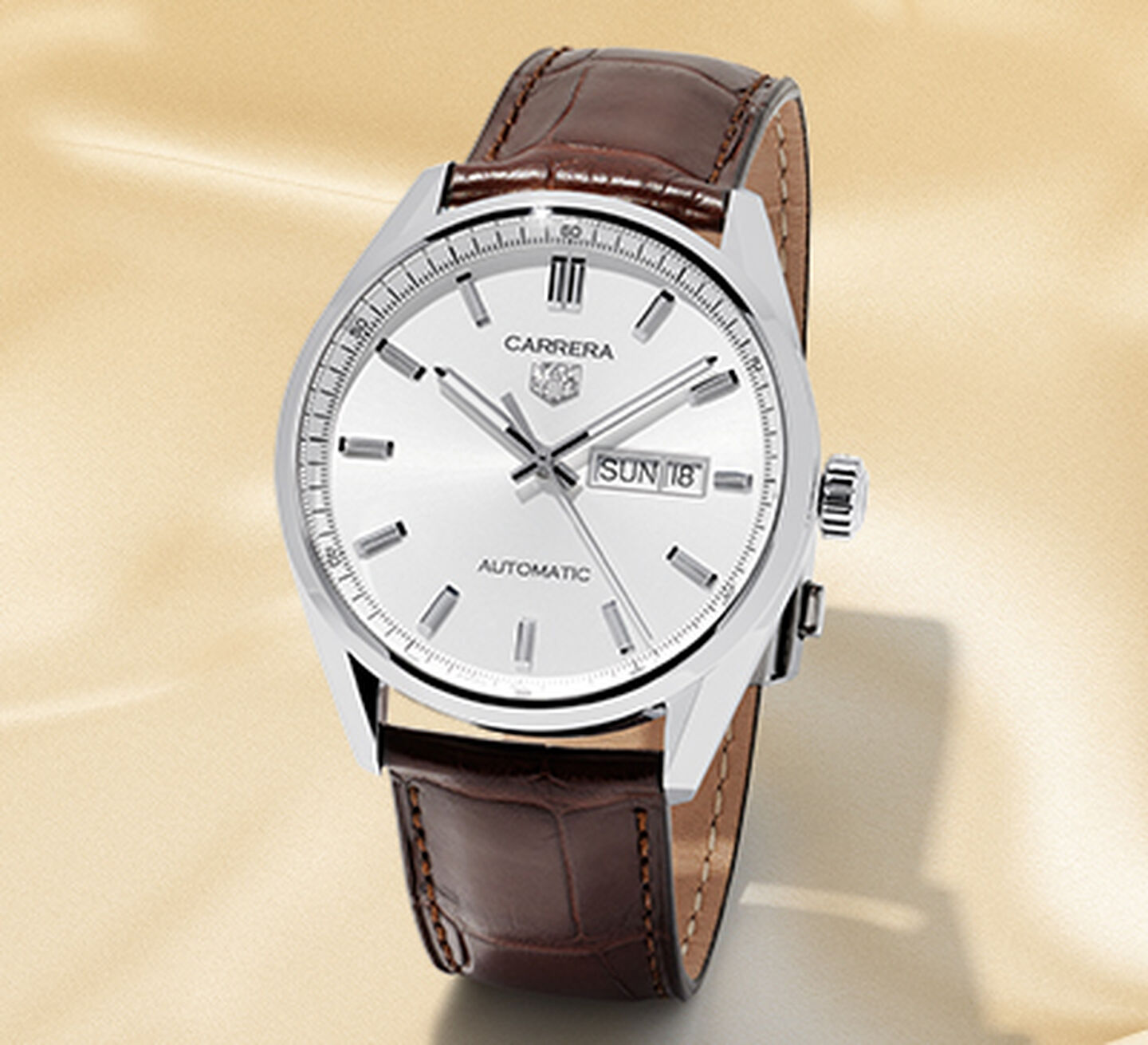 Tag Heuer watch with white dial on brown leather alligator strap with gold satin background