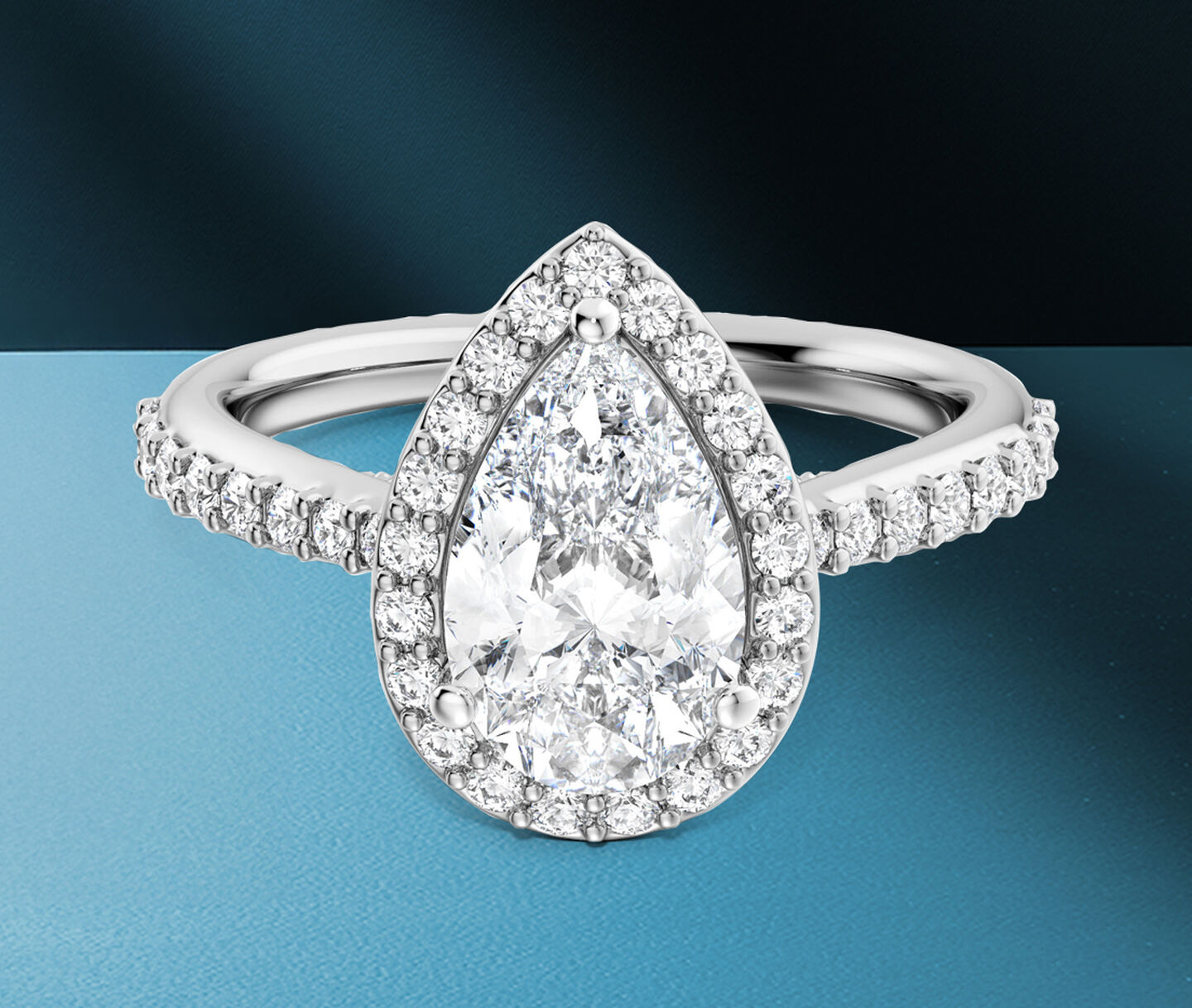 Birks 1879 pear-cut diamond engagement ring on a blue background.