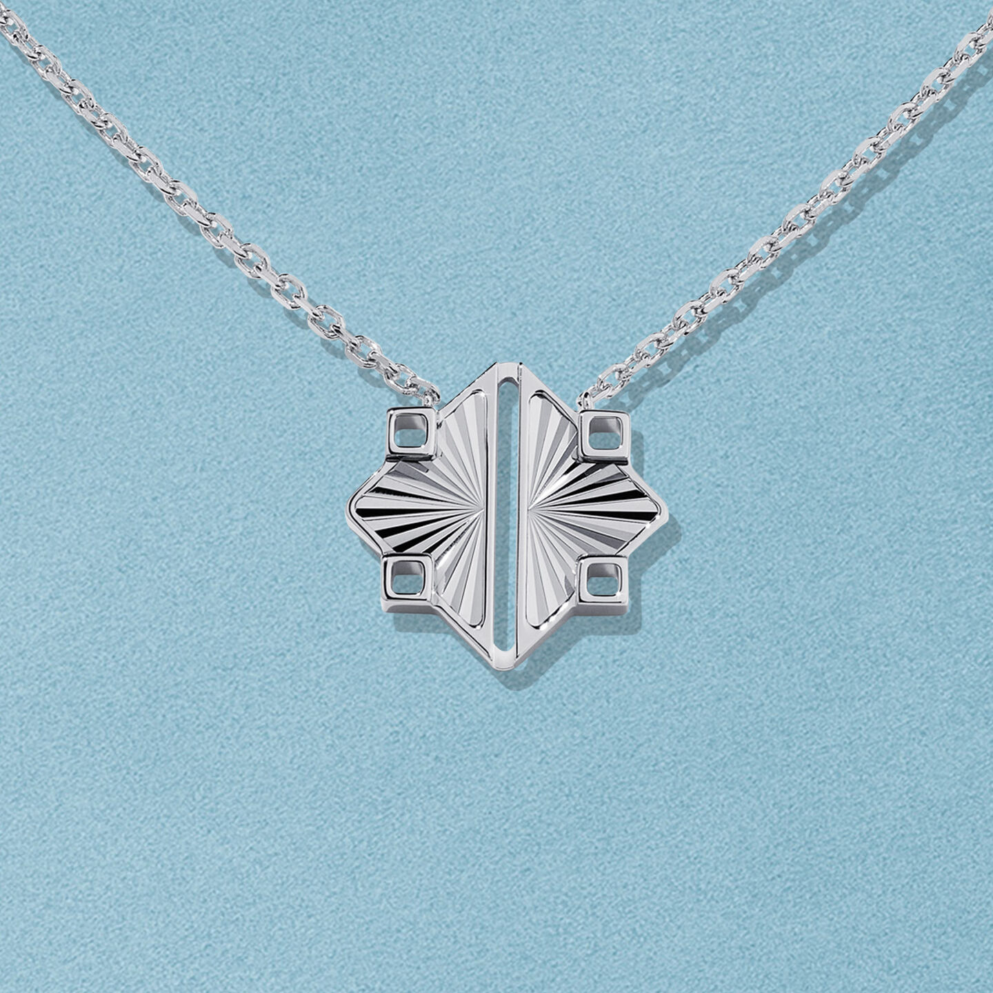 Collier en argent Birks Muse sur un fond bleu.