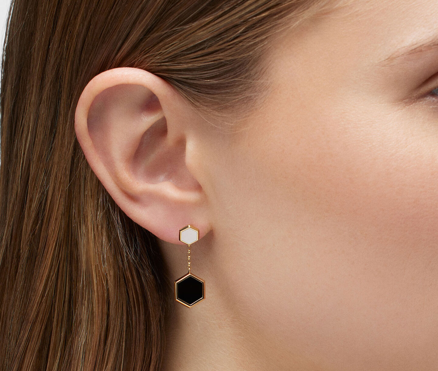 Une femme porte les boucle d'oreilles Birks Bee Chic en or jaune.