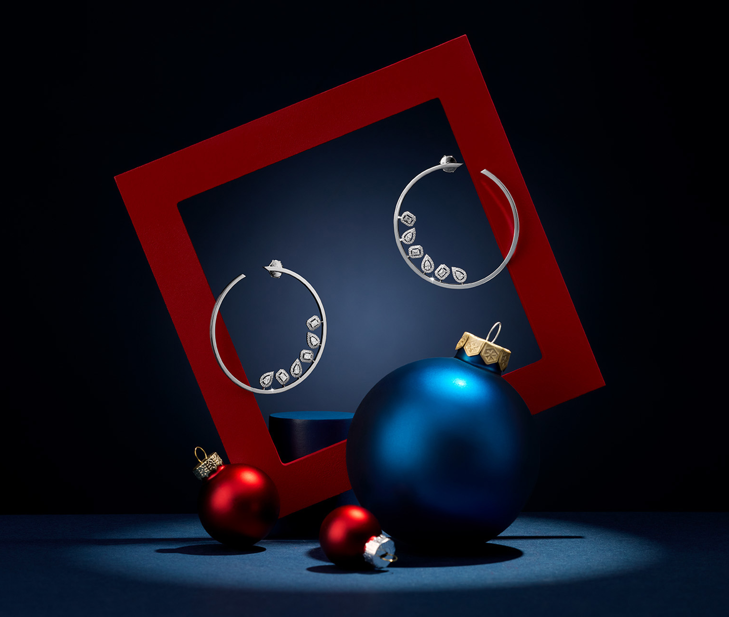 Messika My Twin diamond hoop earrings on a holiday background.