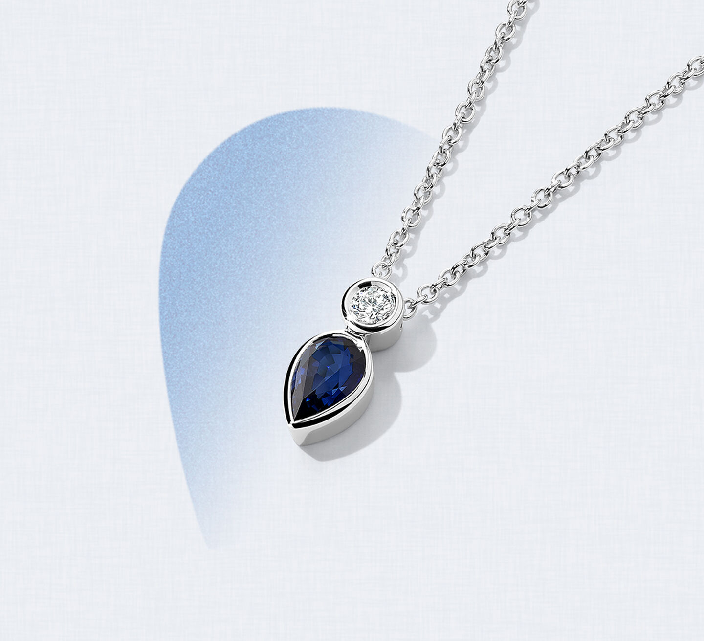 A sapphire pendant on white gold chain with a diamond accent stone