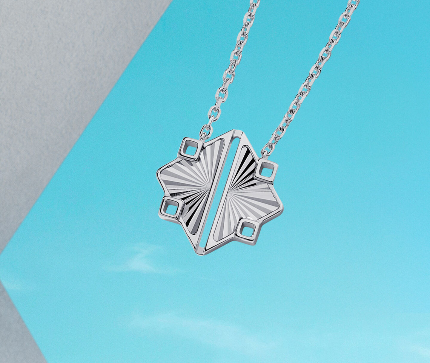 Birks Muse silver pendant on a blue background.