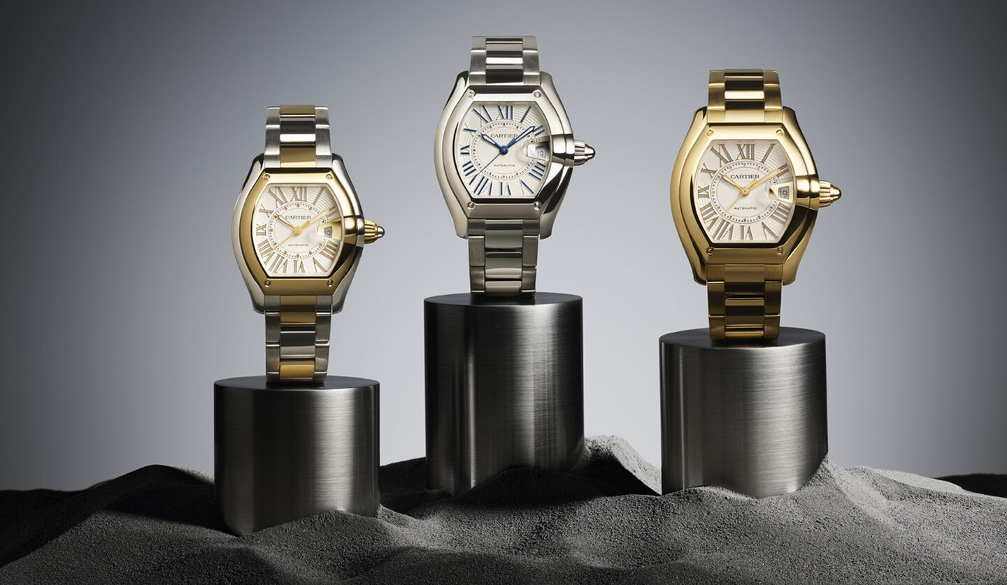Three Cartier Roadster watches on a dark background.