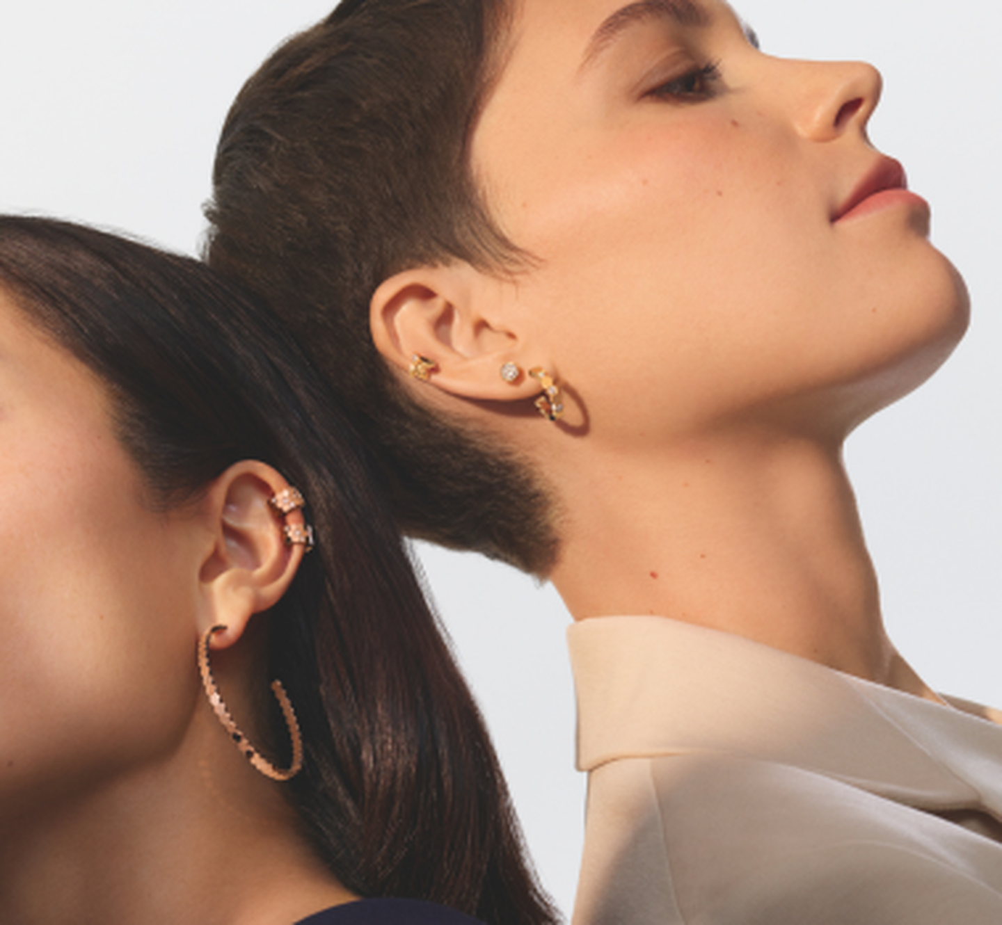 Models wearing a pair of Bee My Love earrings on a  white-grey background.