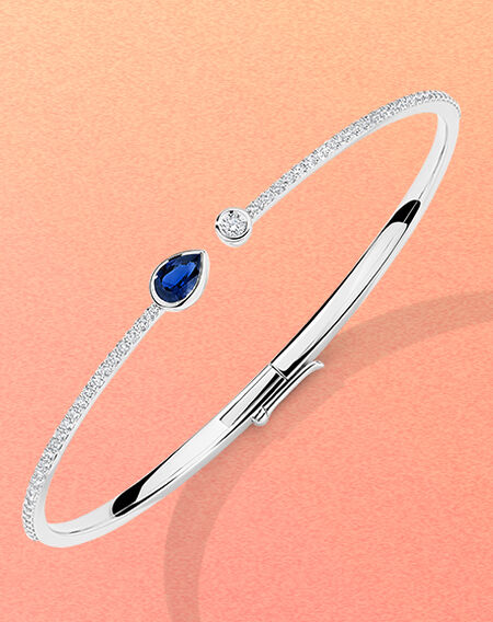 Manchette avec diamants et saphir Birks Splash sur un fond rose et orange