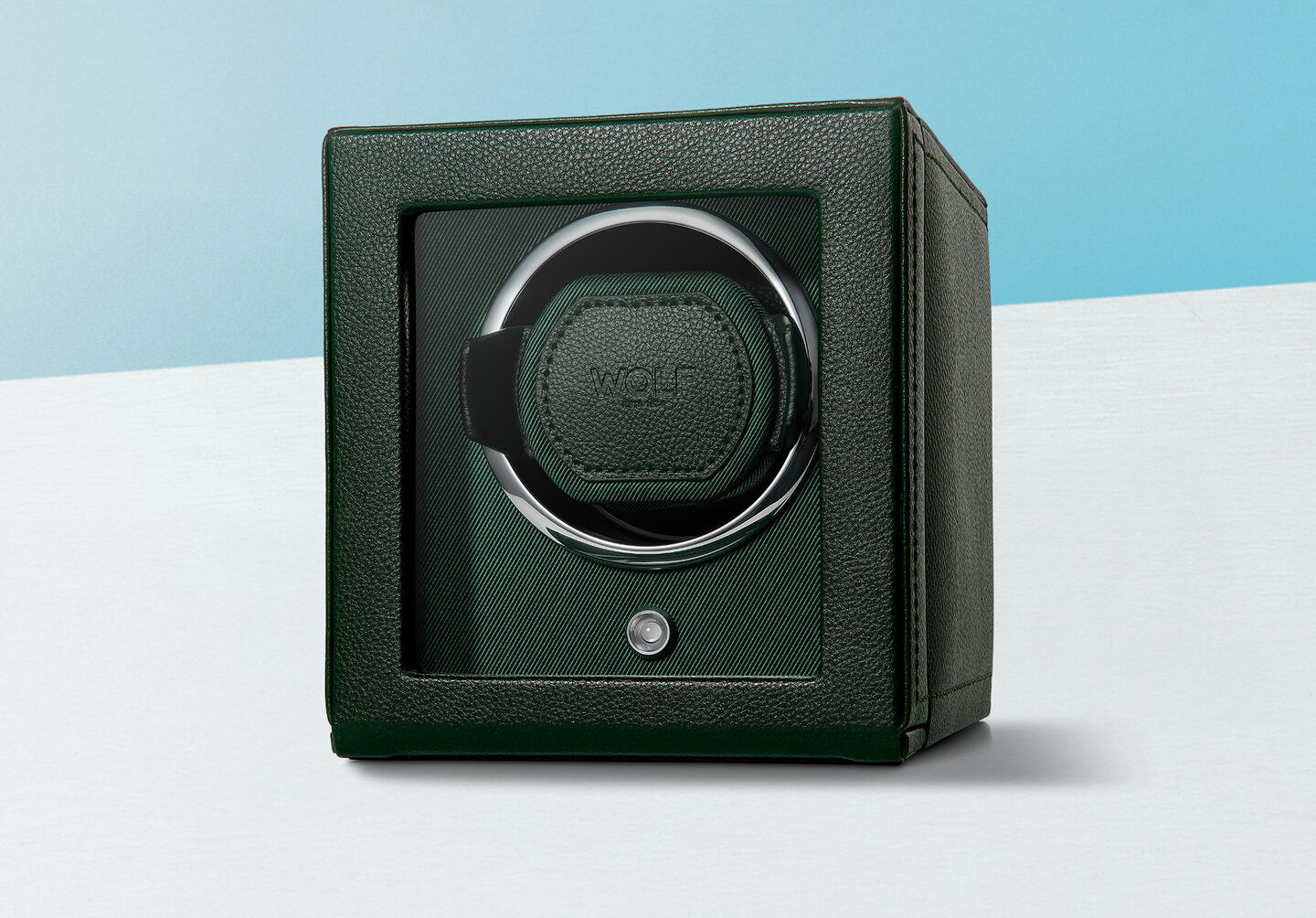 Remontoir vert de Wolf sur un fond bleu.