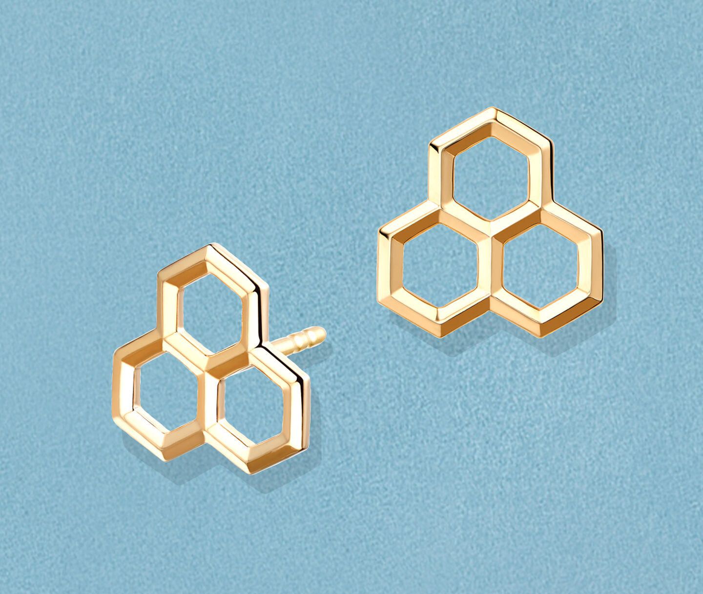 Boucles d'oreilles Birks Bee Chic en or jaune sur un fond bleu.