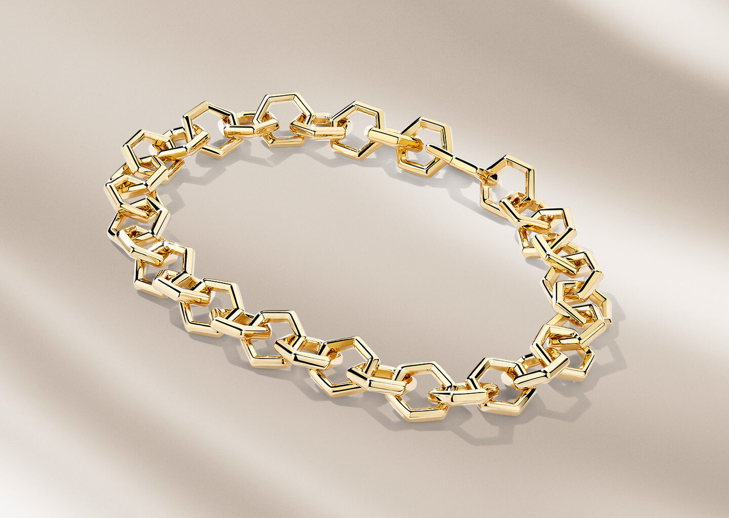 Bracelet Birks Bee Chic en or jaune sur un fond bleu.