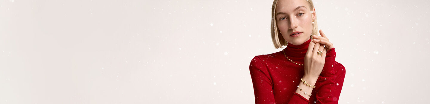 Une personne portant des bijoux en or jaune Marco Bicego et Birks 