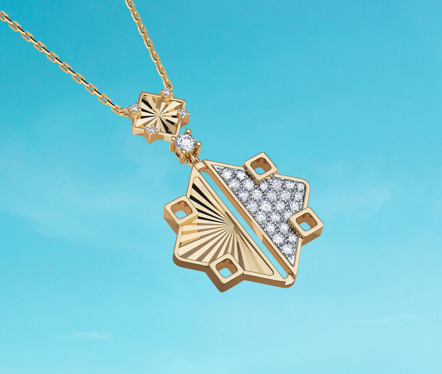 Birks Muse yellow gold and diamond drop pendant on a blue background.