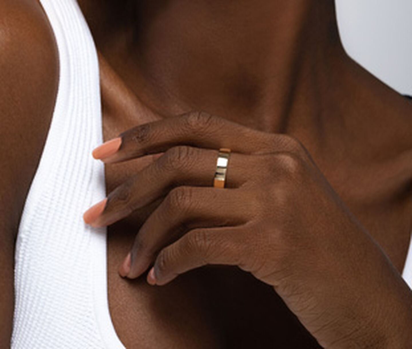 Une femme porte une bague en or jaune de Birks.
