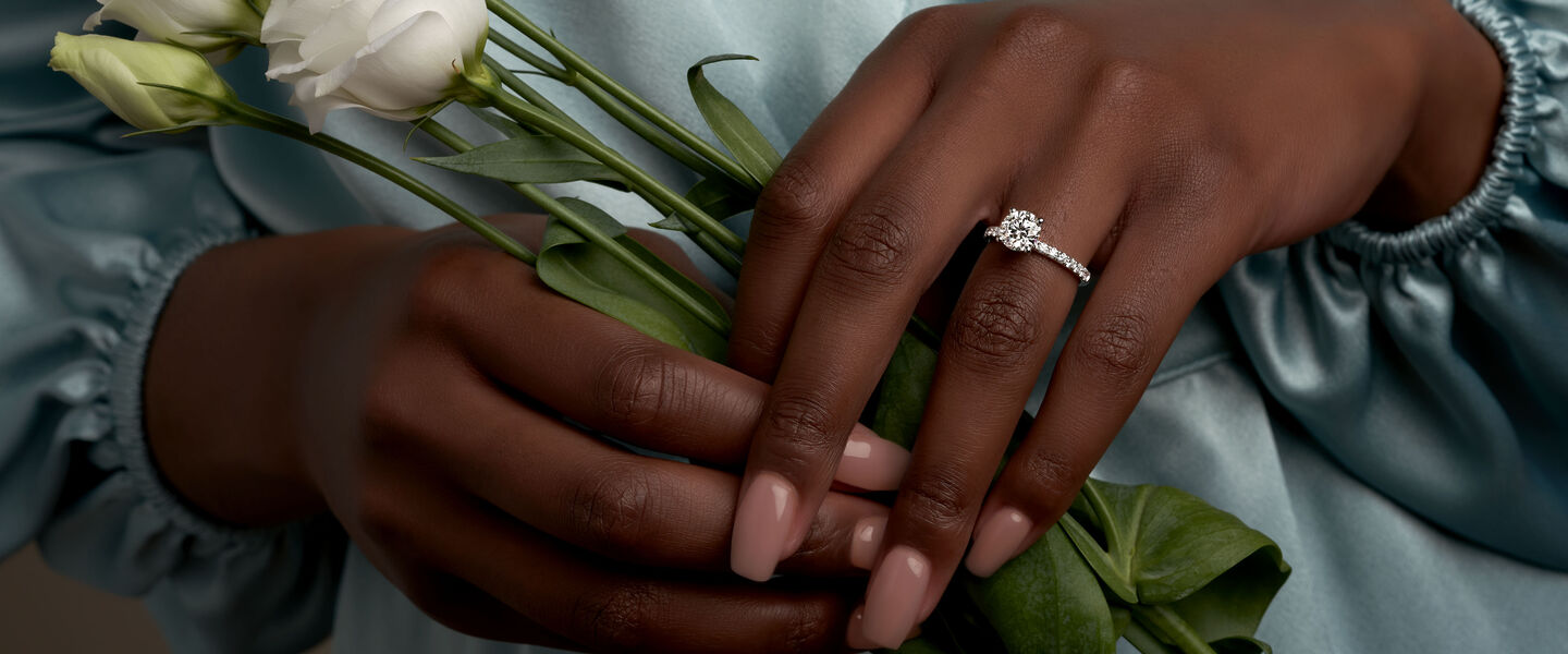 A woman wearing a Birks diamond engagement ring.