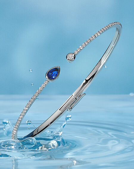 Birks Splash sapphire diamond bangle on a blue water background.