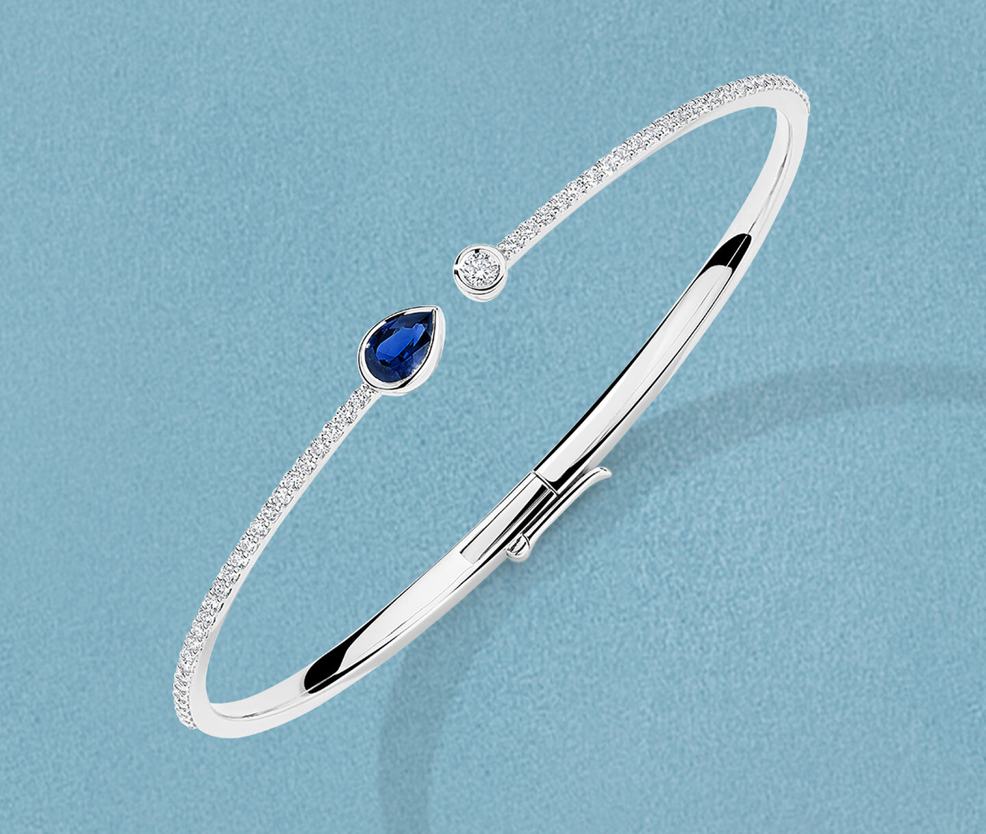 Bracelet Birks Splash avec saphir et diamants sur un fond bleu.