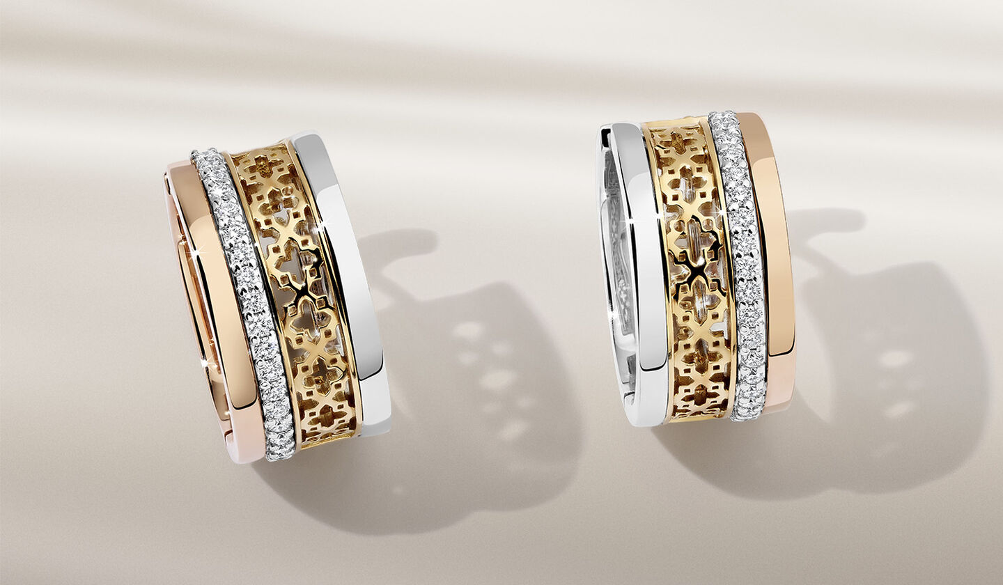 Birks Dare to Dream diamond earrings on a beige background.