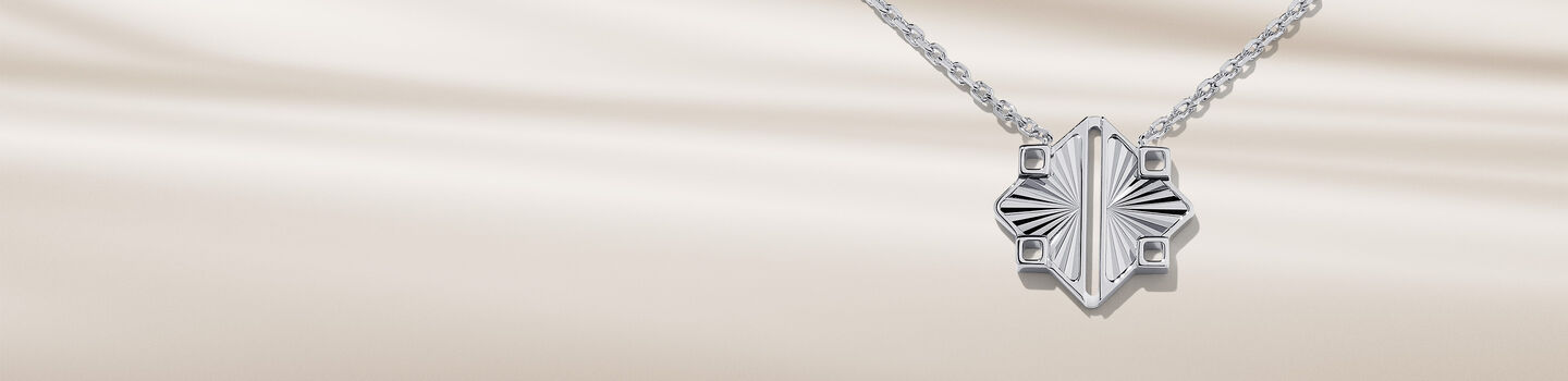 Collier Birks Muse en argent sur un fond bleu.