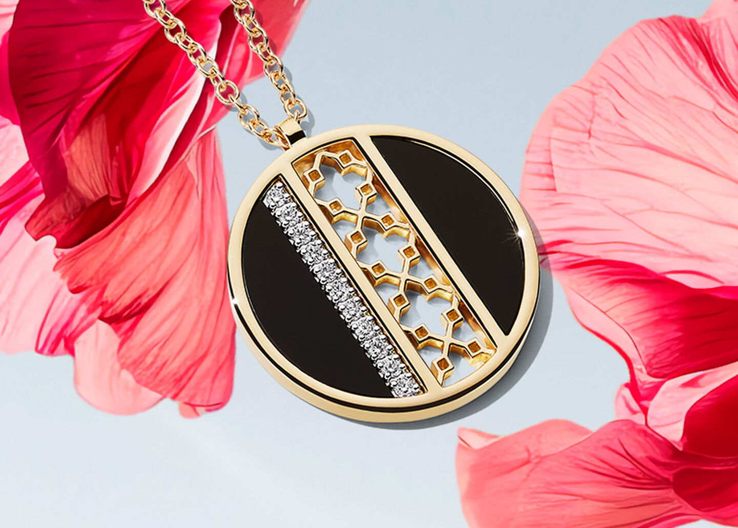 A Birks Dare to Dream black onyx and diamond medallion on a pink flower and light sky blue background.