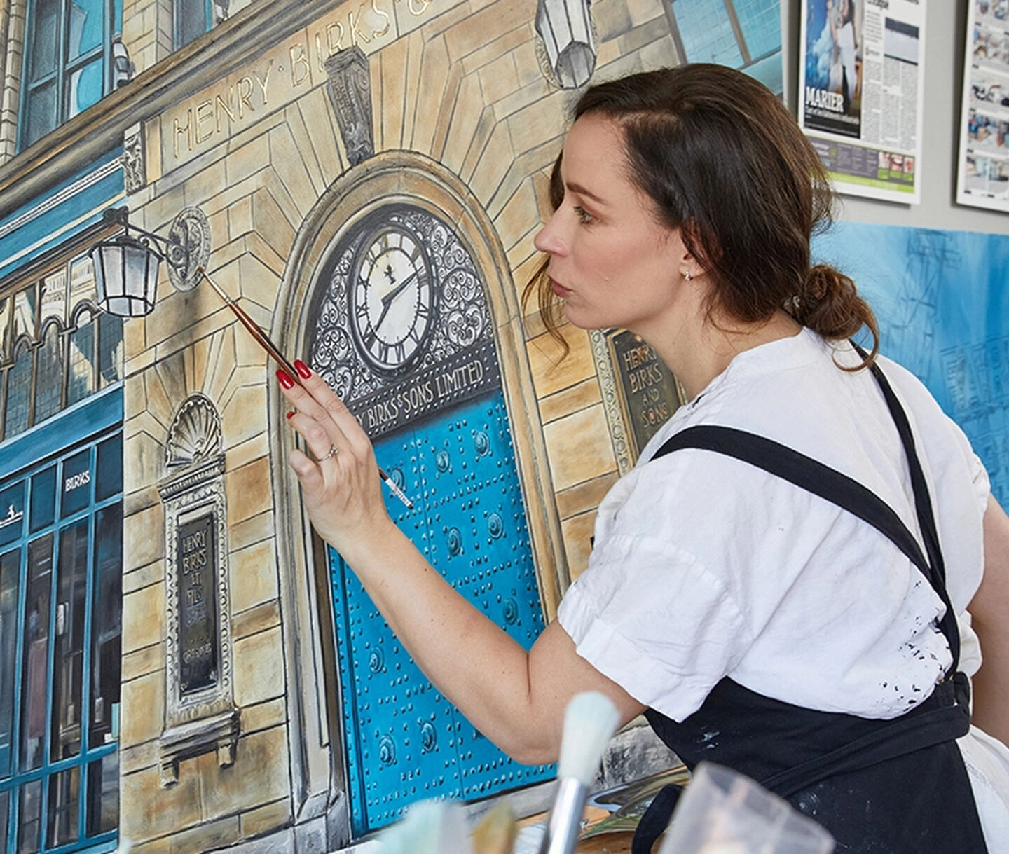 Artist Stephanie Goulet painting the iconic Maison Birks storefront