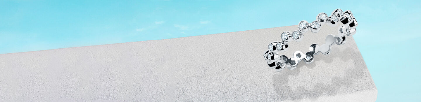 Birks Iconic white gold and diamond Splash ring on a blue background.