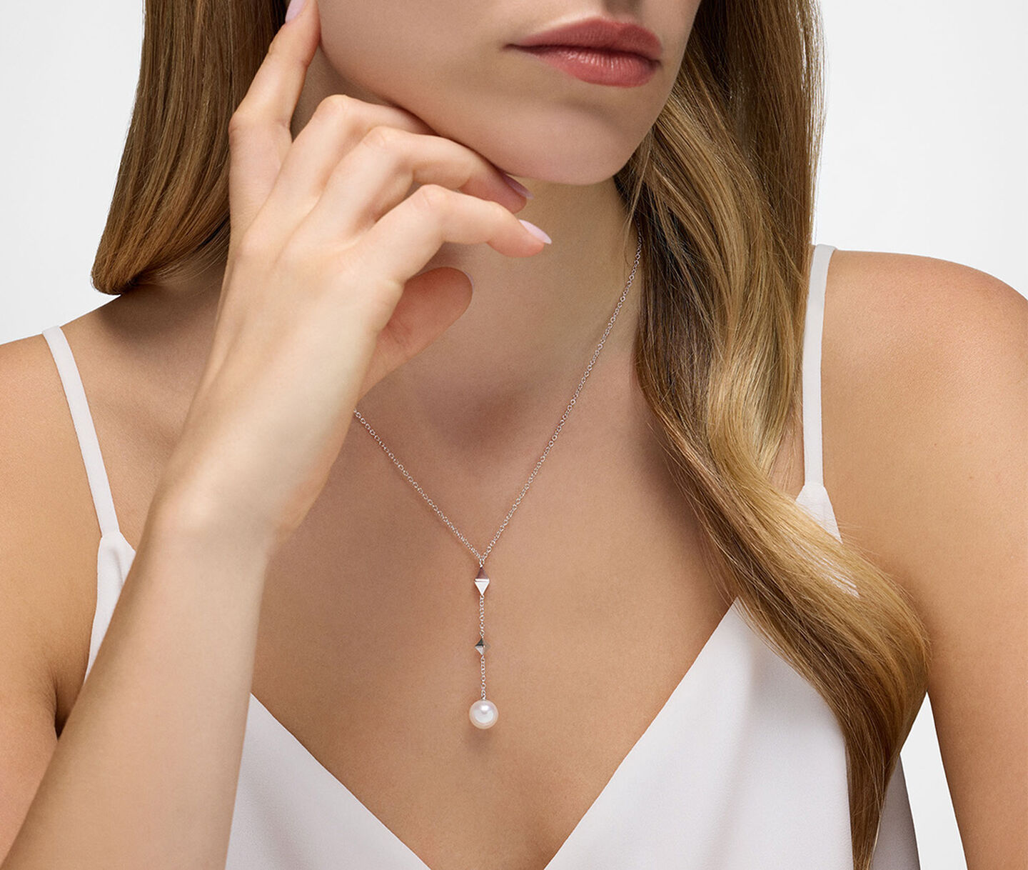 Une femme porte un collier Birks Rock & Pearl en argent.