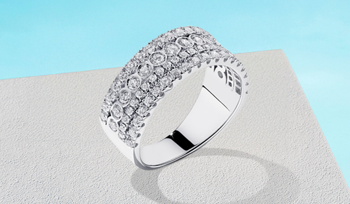 Bague Birks Splash en or blanc avec diamants sur fond bleu.