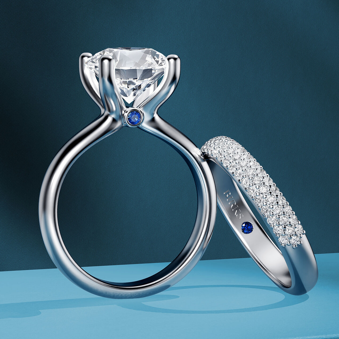 Bague de fian&ccedil;ailles et alliance de mariage Birks Blue sur un fond bleu.
