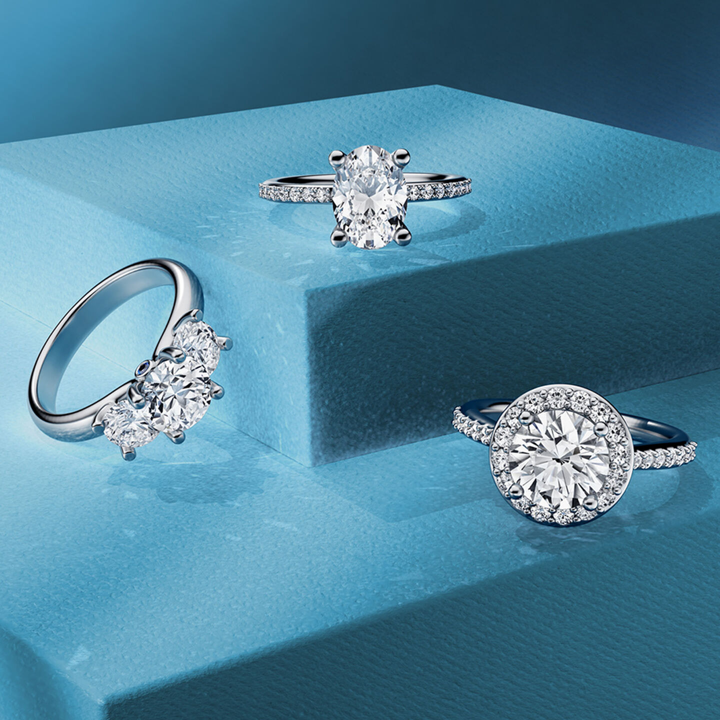 Birks Blue diamond engagement ring and wedding band on a blue background.