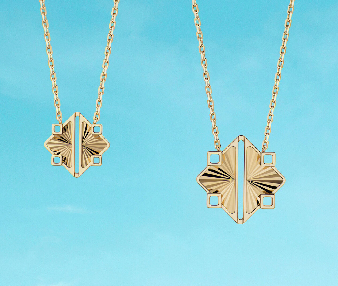 Two Birks Muse yellow gold pendants on a blue background.