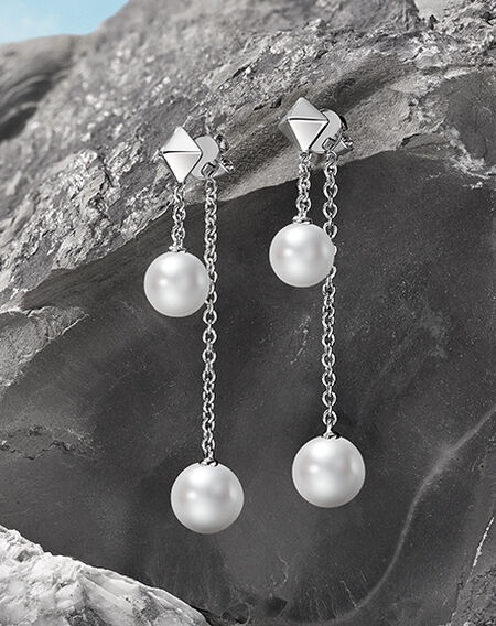Birks Rock and Pearl silver earrings on a mountain background