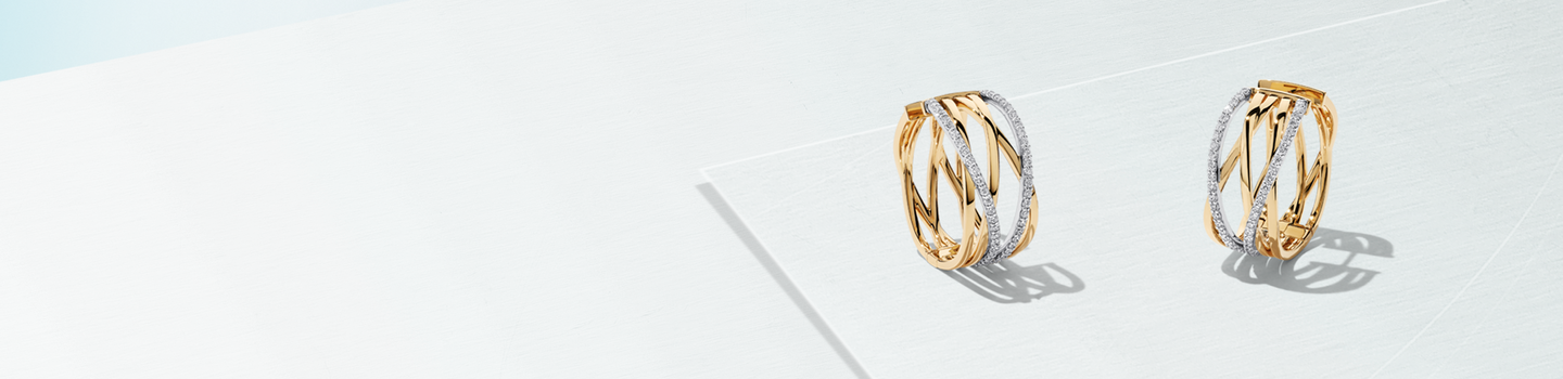 Birks Rosée du Matin gold and diamond hoop earrings on a baby blue background