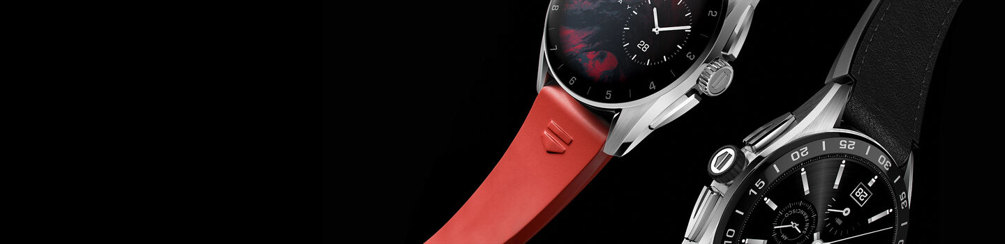 Two TAG Connected watches over a black background