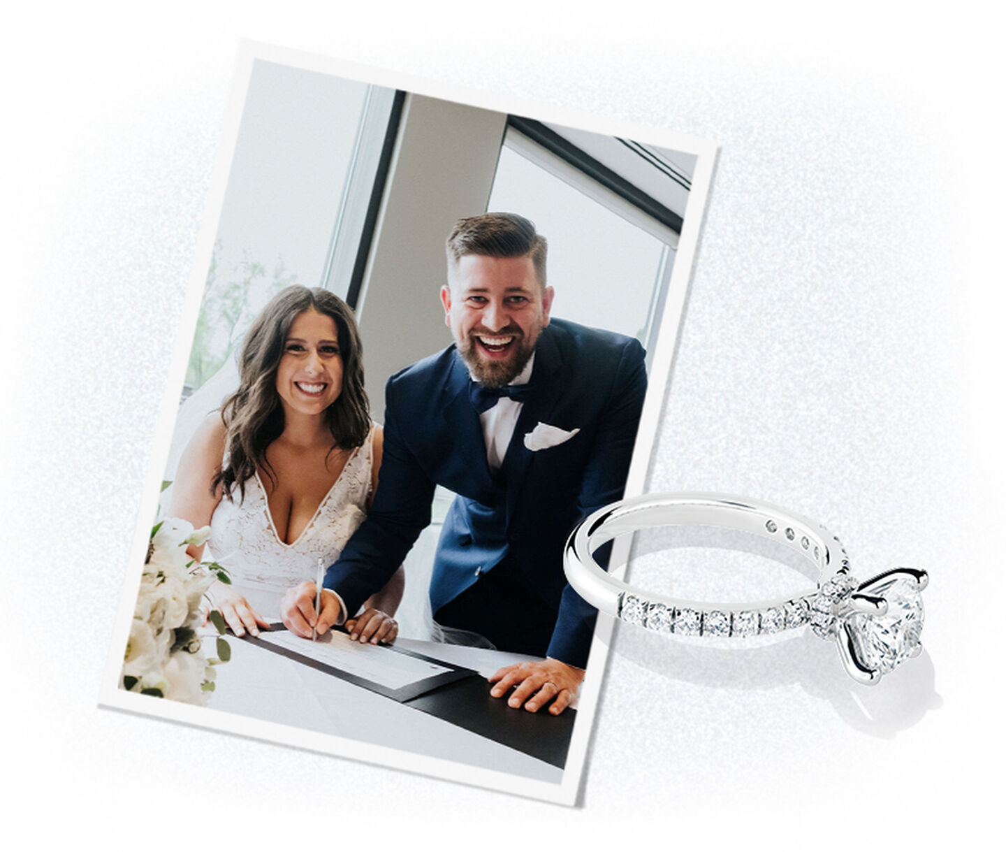 A couple sign their marriage certificate while smiling joyfully at the camera