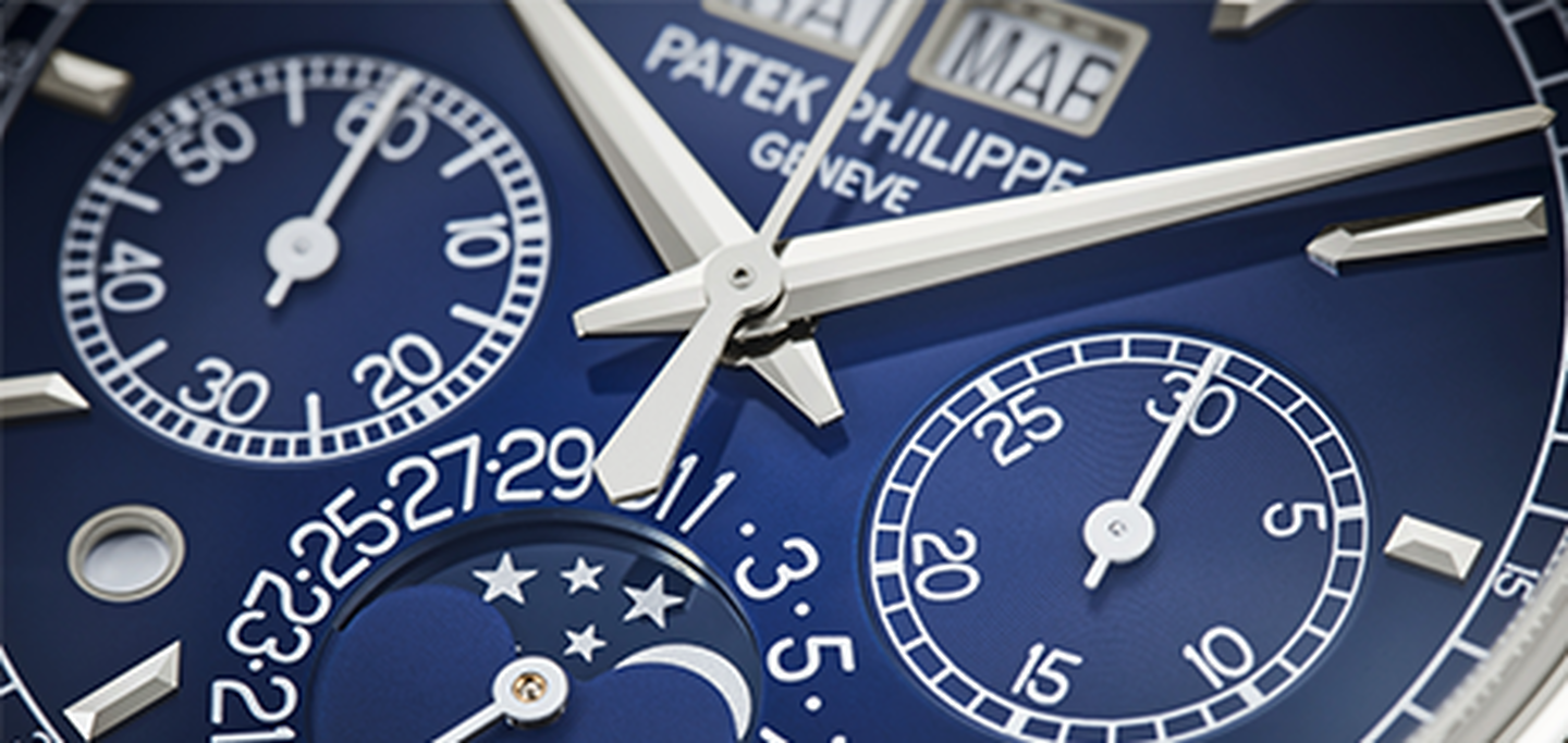 A closeup shot of a Patek Philippe watch with a blue face