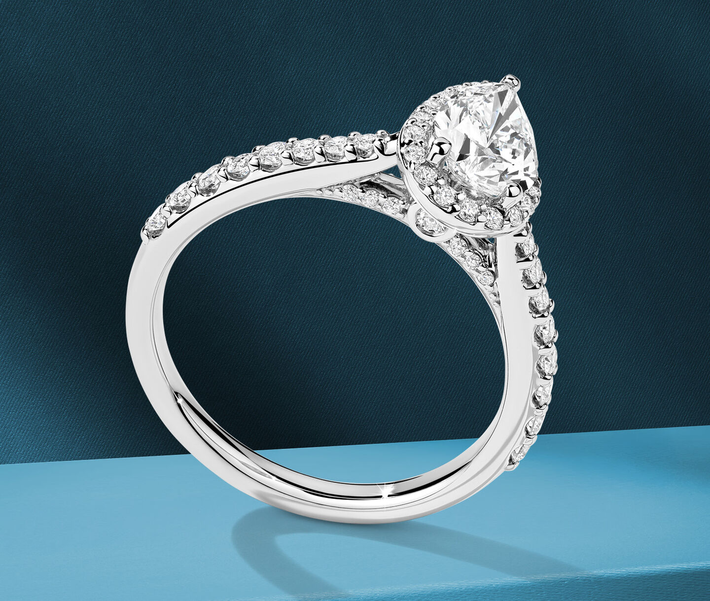 Birks 1879 pear-cut diamond engagement ring on a blue background.