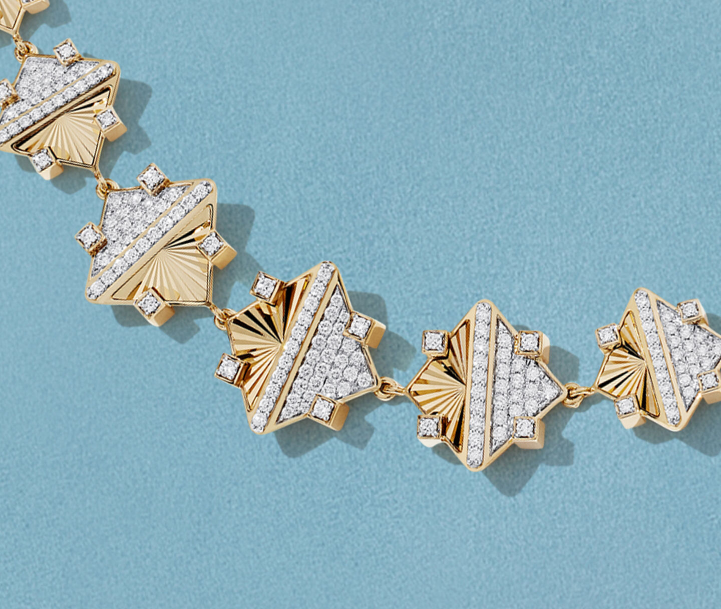 Birks Muse yellow gold and diamond bracelet on a blue background.