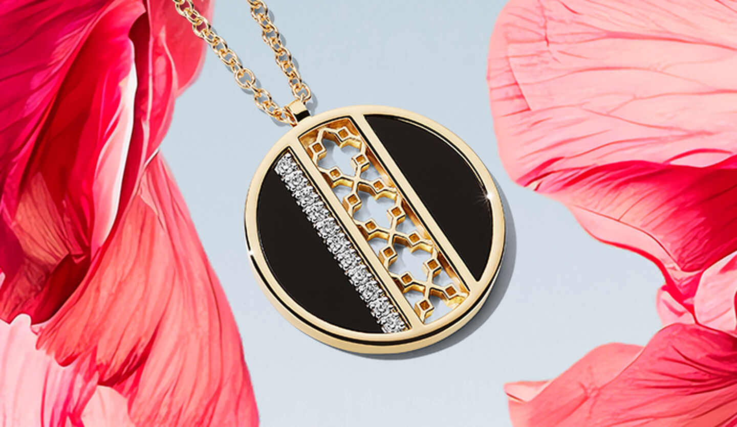 Un médaillon Birks Dare to Dream en onyx et diamants sur une fleur rose.