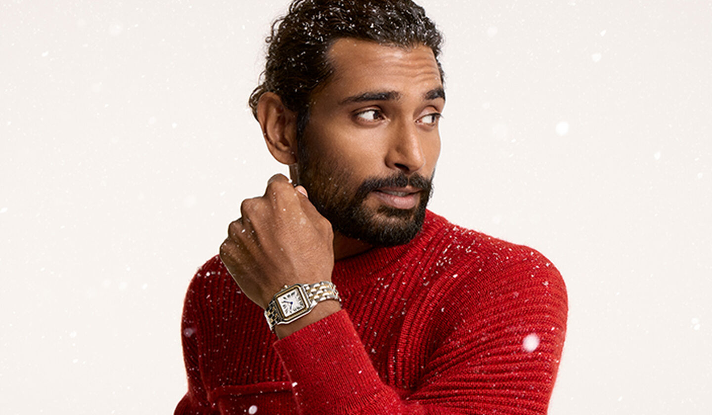 A person wearing a Cartier panthere watch on a beige snowy background