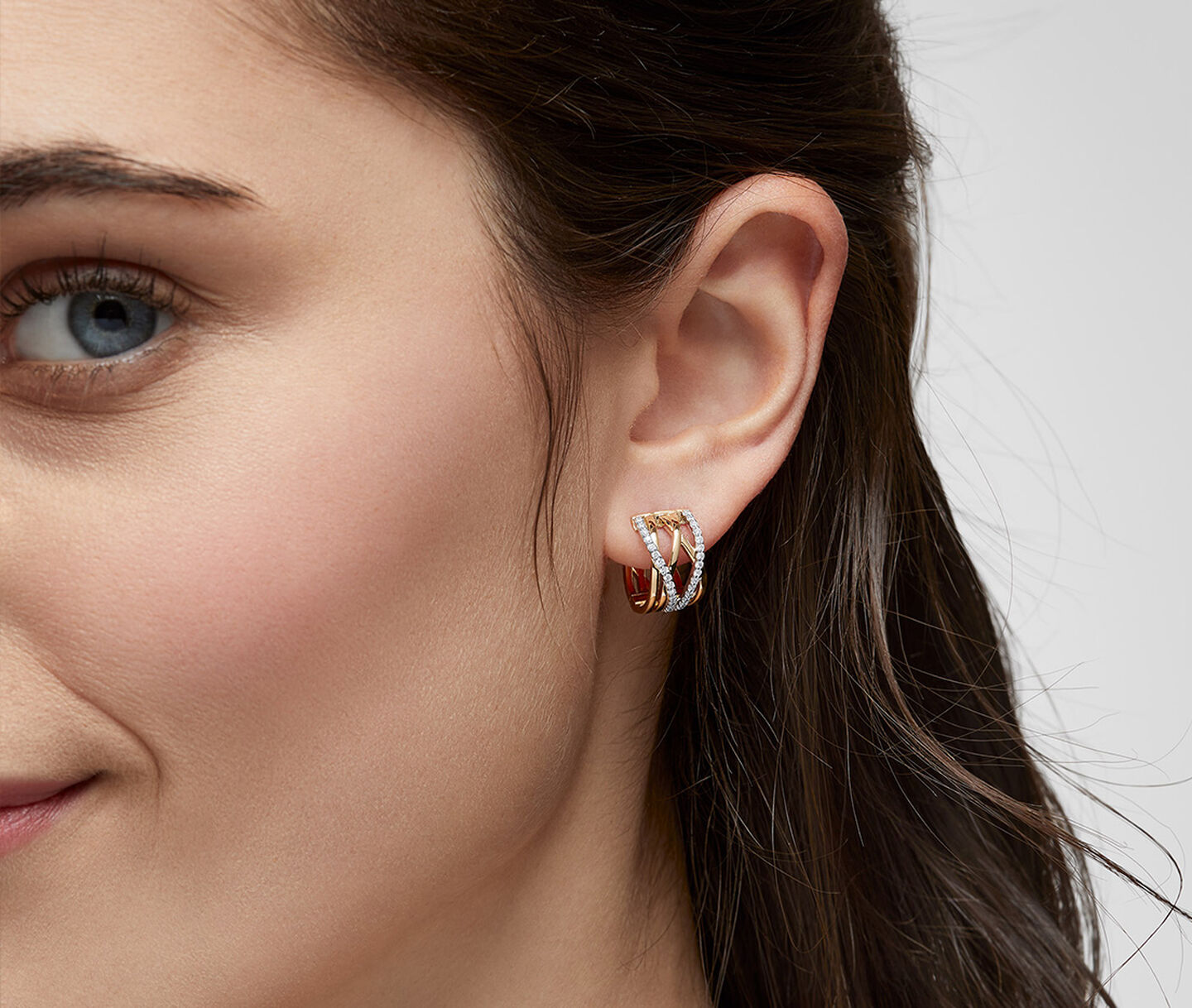 A woman wearing Birks Rosee du Matin diamond and yellow gold earrings.