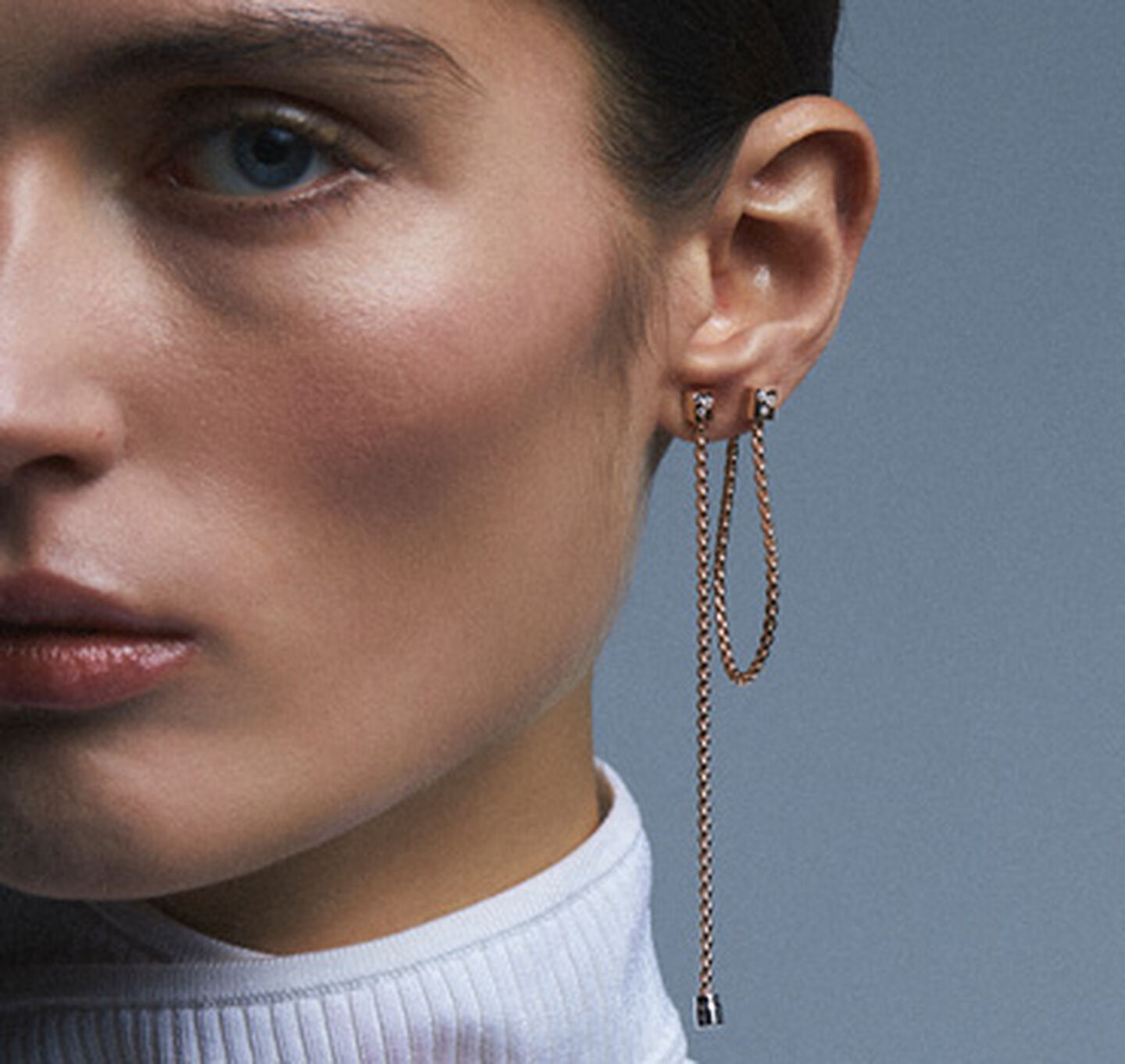Une femme porte les boucles d'oreilles FOPE.