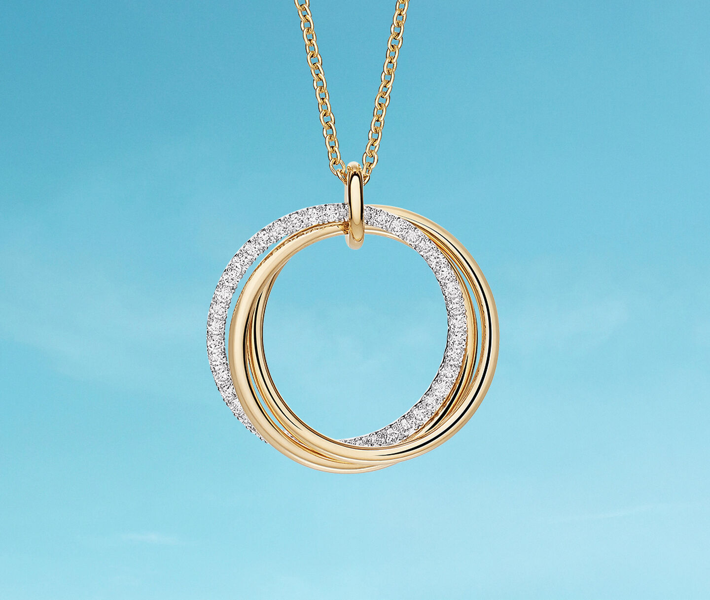 Birks Rosee du Matin gold necklace on a blue background.