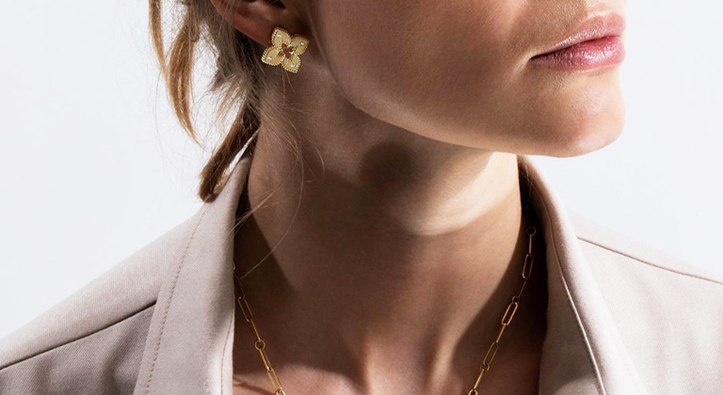 A model wearing Roberto Coin Princess Flower gold earrings.