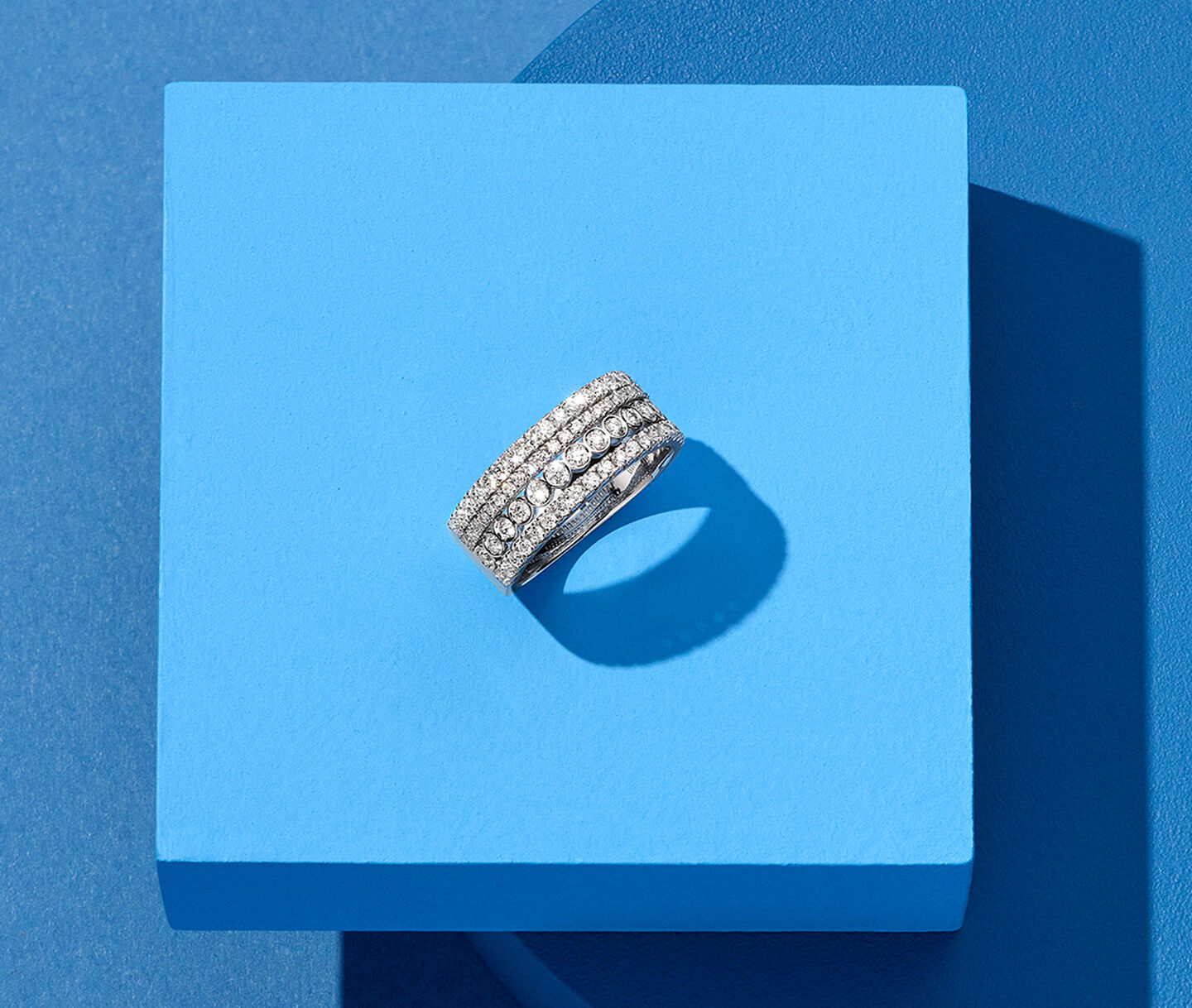 Bague Birks Splash avec diamants sur un fond bleu.
