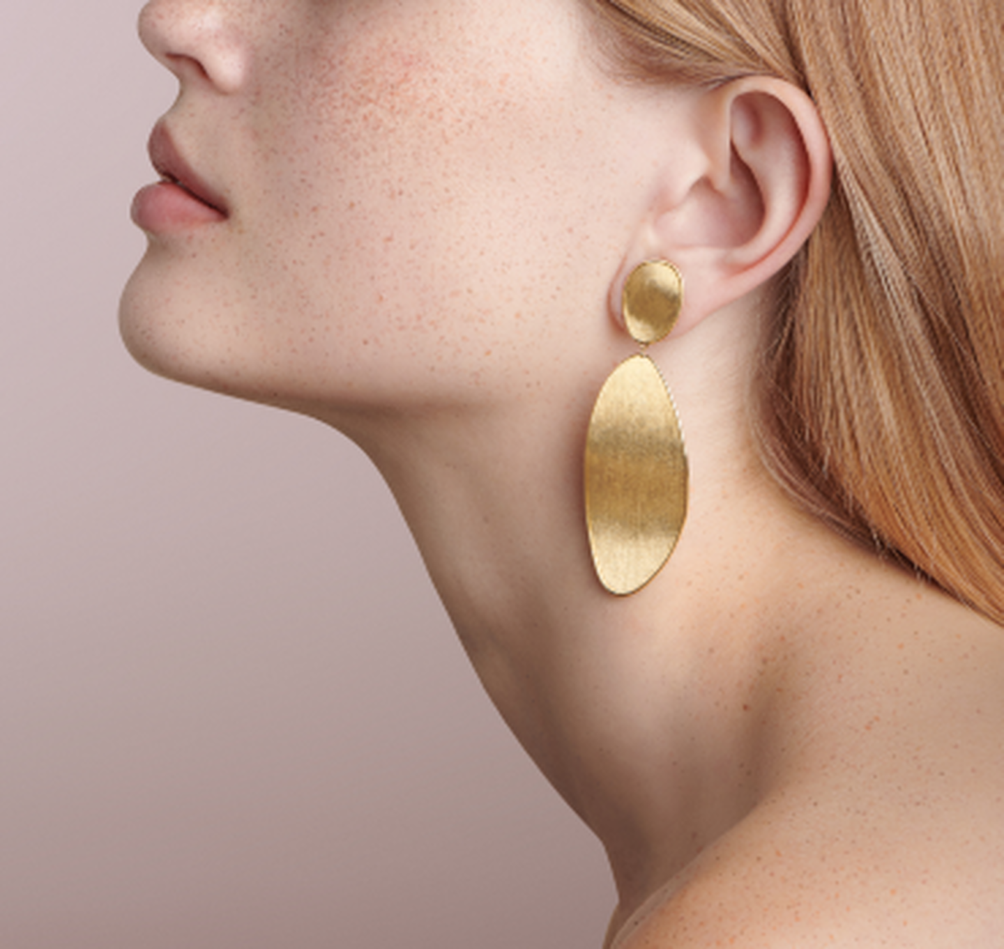 Une femme porte les boucles d'oreilles Lunaria de Marco Bicego.