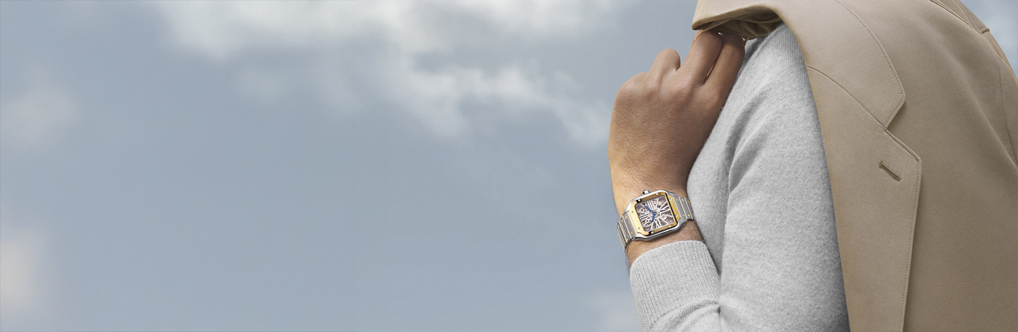 Un homme porte une montre Santos de Cartier